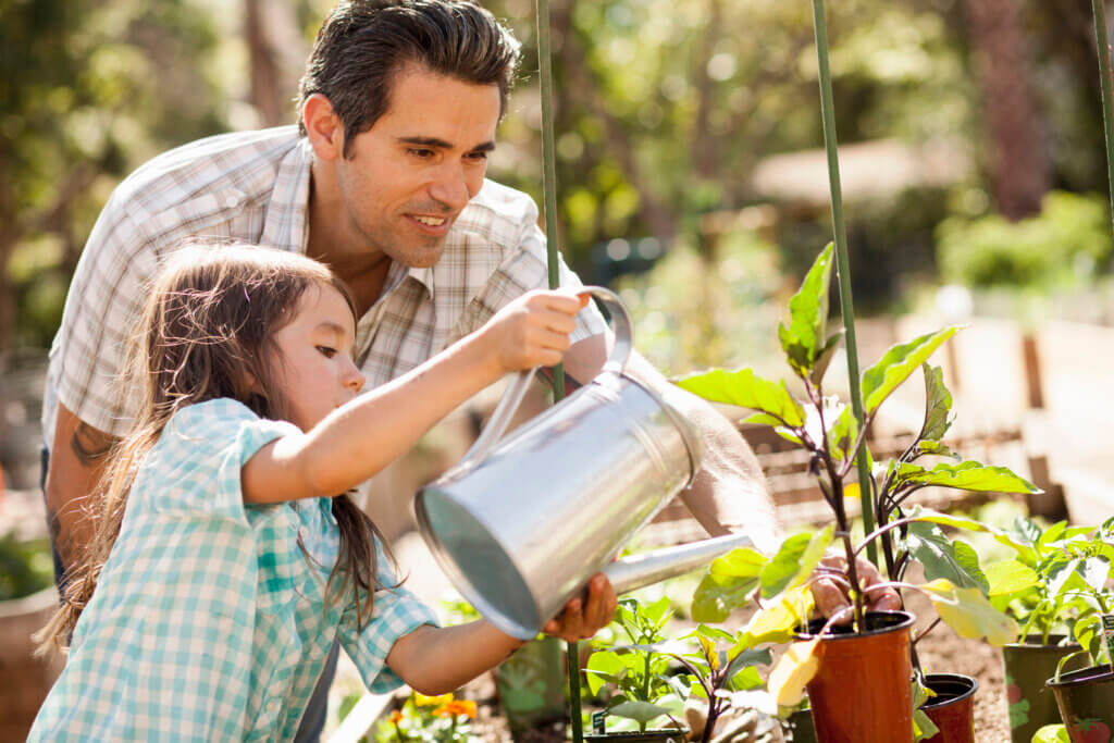 A father and daughter caring for their plants after having made charitable donations to a non-profit in their community.