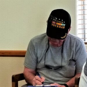 A veteran filling in a form for a Miami County Kansas veterans support program.