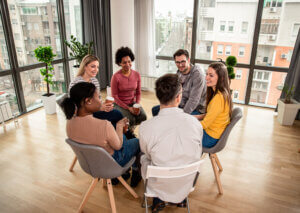 A group seated in a circle in a bright meeting room