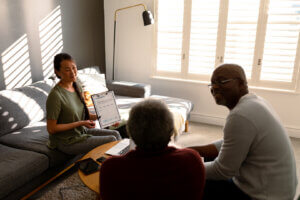 A lawyer and a family sit on a couch, reviewing documents together for estate planning and administration.