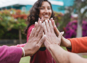 A woman joins hands with others, symbolizing the collaborative spirit of education scholarships.