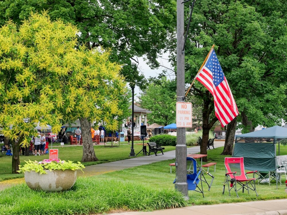 A Miami County park with an American flag, shade trees and benches