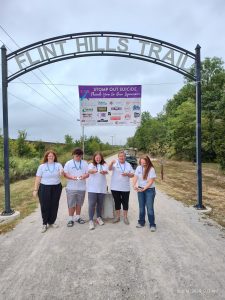 A group walking together under a park entrance arch