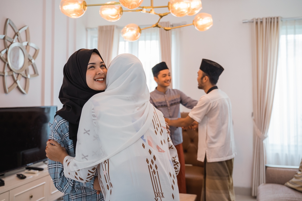 Family and friends greeting each other at home, showing ways to give that build community resilience through care and connection.