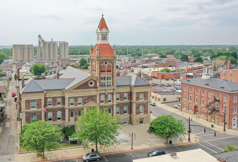 A historic brick county courthouse and clock tower above a small midwestern town's main street