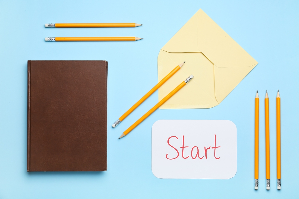 Notebook, pencils, envelope, and a “Start” card arranged on a desk, illustrating how to start an endowment.