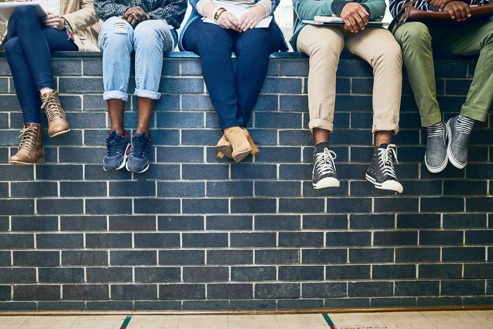 Group of students sitting together with notebooks, illustrating scholarship essay examples about yourself and personal stories used in scholarship applications.