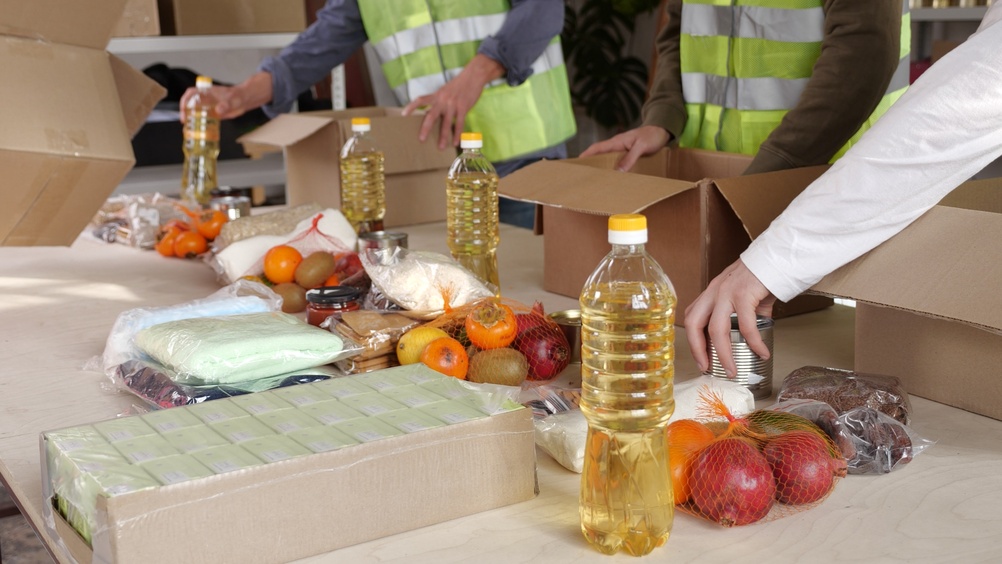 Volunteers packing food donations into boxes, illustrating community support work related to a grant proposal example.