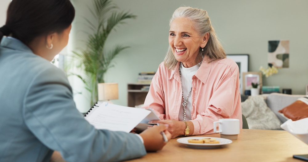 A senior woman reviewing will documents with her attorney, asking what is a bequest in a will and how to word one.