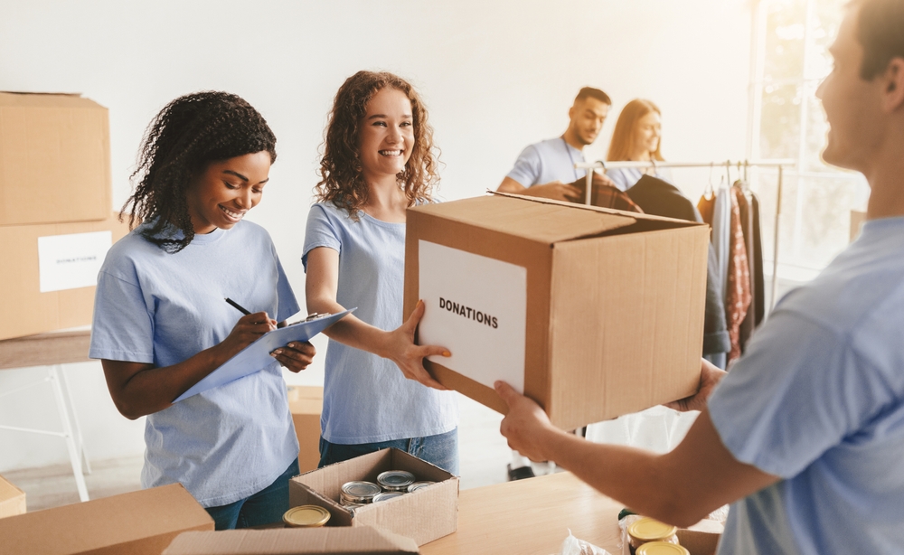 Volunteers sorting donated goods at a community center, the local work a bequest donation can fund for years.